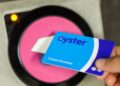 person using pink oyster card reader