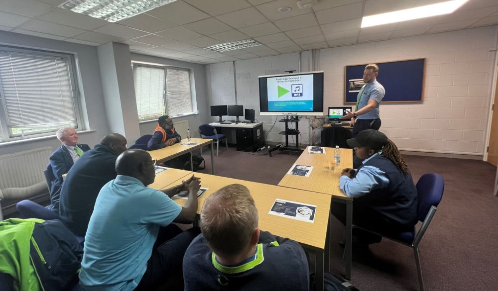 Group of new London tram drivers attending classroom training wearing high-visibility vests in 2025.