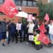 Group of bus drivers in standing together outside the depot.
