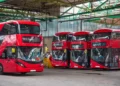 Red double-decker buses parked inside a London bus garage