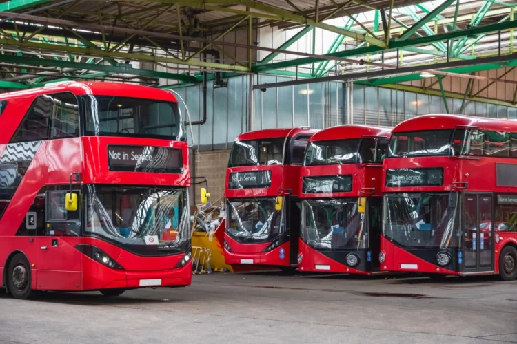 Red double-decker buses parked inside a London bus garage