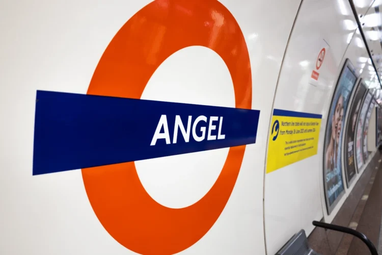Angel London Underground station roundel displayed on a tiled wall inside the station.