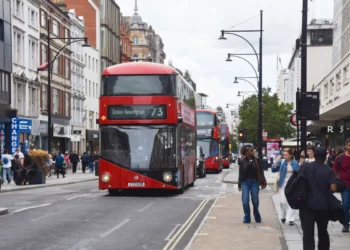 Red double-decker bus travelling along Oxford Street in Central London.