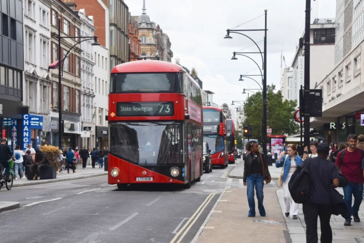 Red double-decker bus travelling along Oxford Street in Central London.